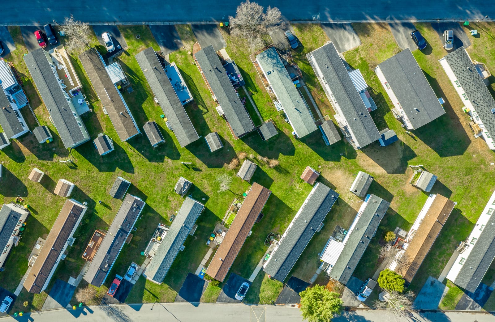 Aerial view looking down on manufactured homes set on landscaped lots along a community street